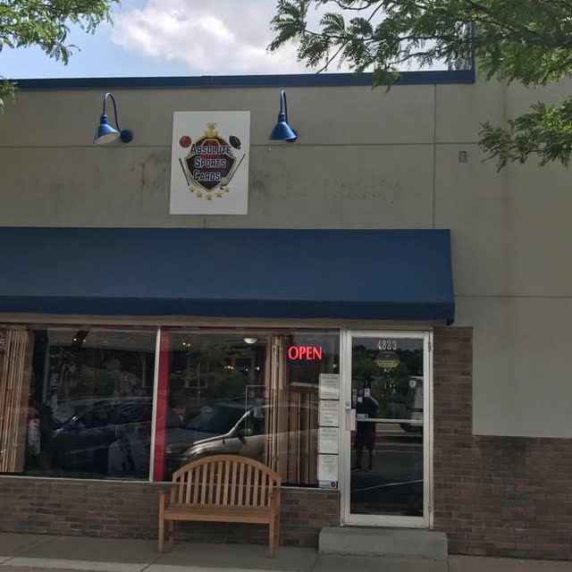 The Absolute Sports Cards storefront with sign, awning and OPEN neon